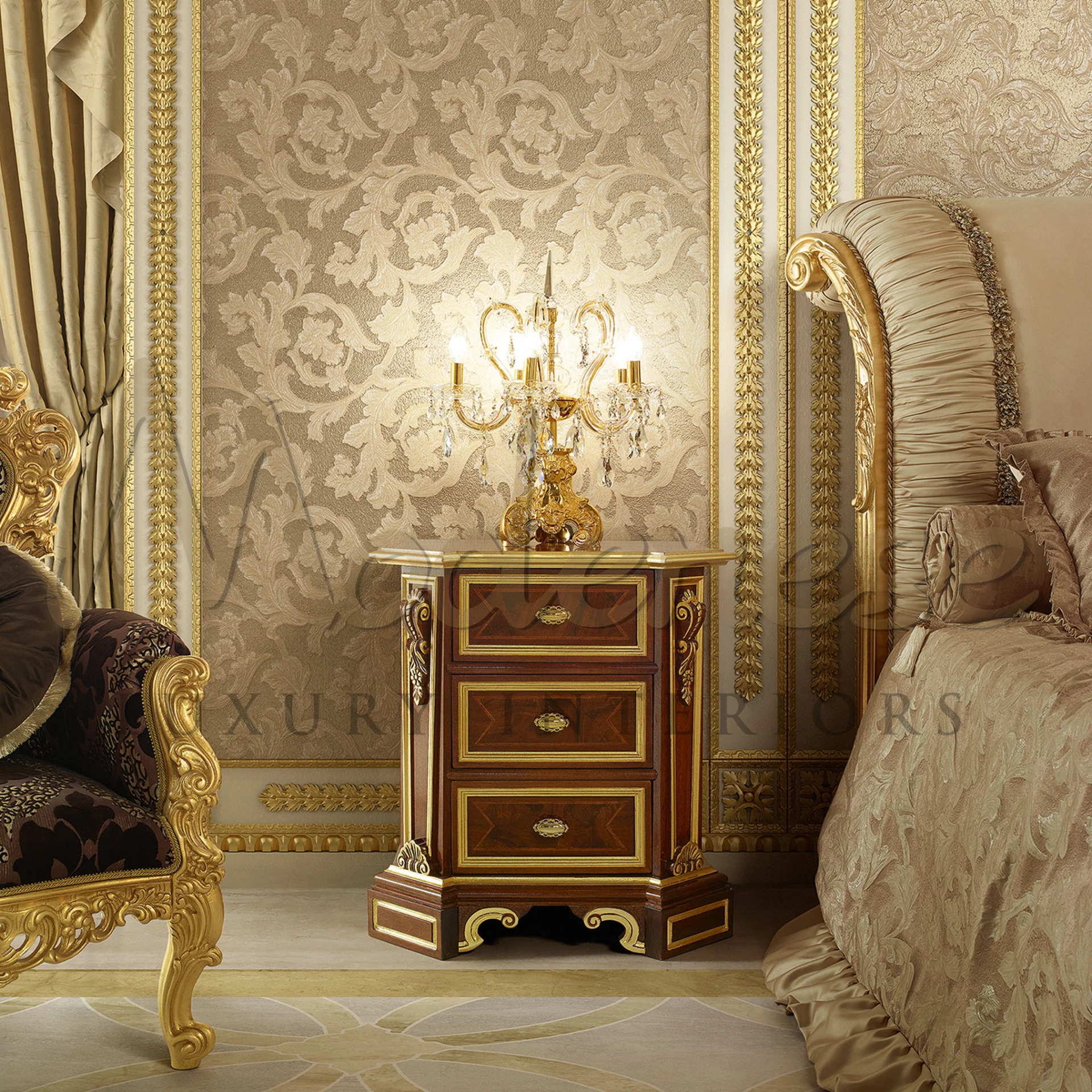 An ornate wooden nightstand with brass fittings and marble top, set against a damask wall, accompanied by a golden candelabra and luxurious furnishings.