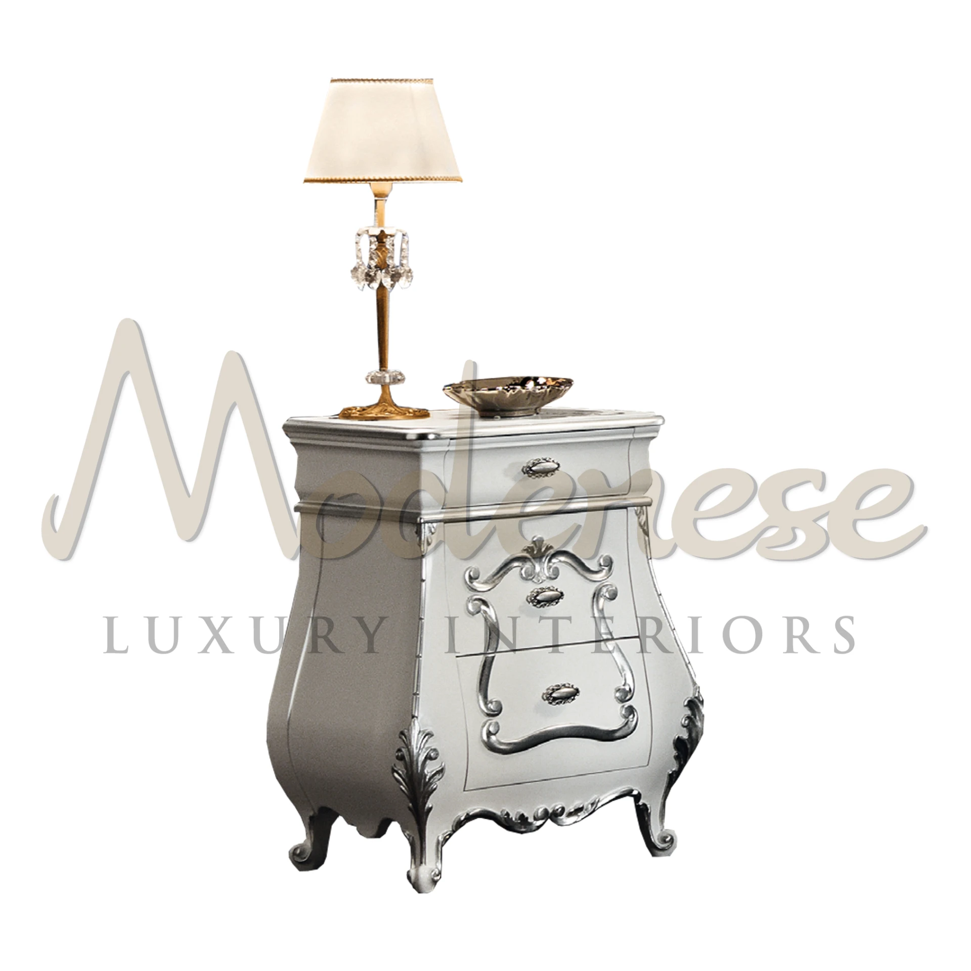 Ornate silver nightstand with baroque design details, accompanied by a gold and crystal table lamp with a cream shade, and a decorative gold bowl created by Modenese.