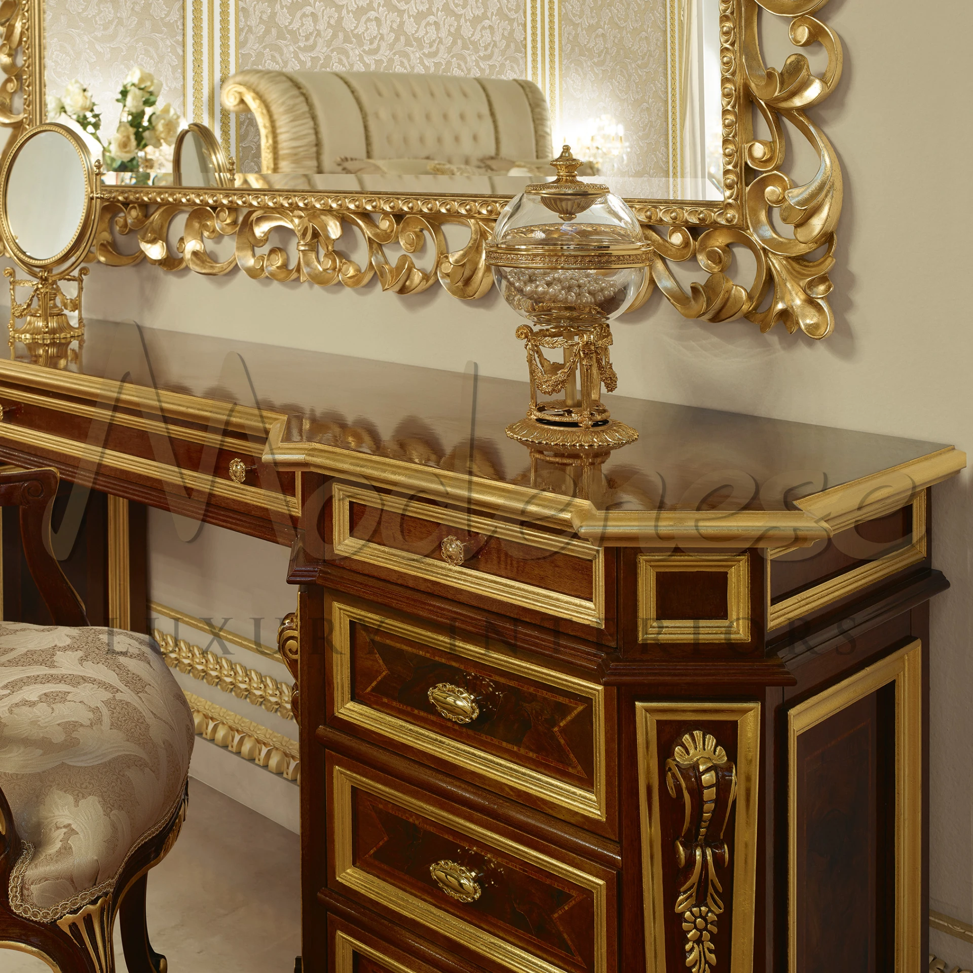 Close-up of a luxurious dressing table with a glossy golden trim, intricate woodwork, and an ornate mirror, featuring a glass candy jar as an elegant accessory.