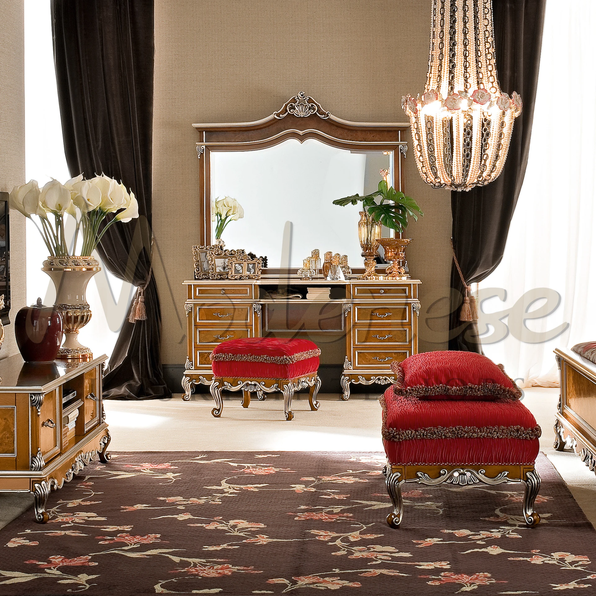 Traditional wooden dressing table with intricate carvings and multiple drawers, paired with a tasseled red stool, adorned with photo frames and perfume bottles.