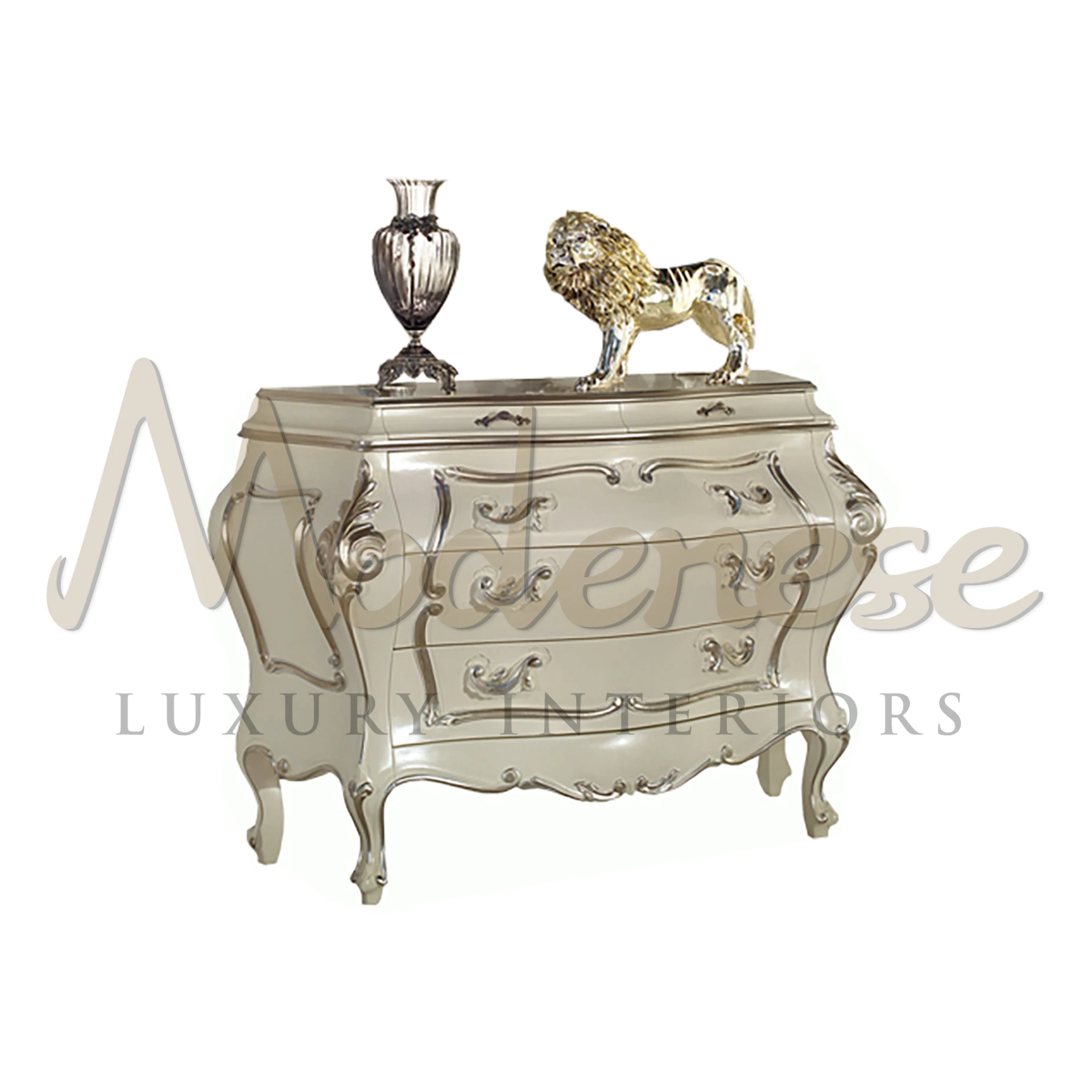 Reflective silver-finished chest of drawers with ornate detailing and sculpted legs, adorned with a decorative vase and lion figurine.