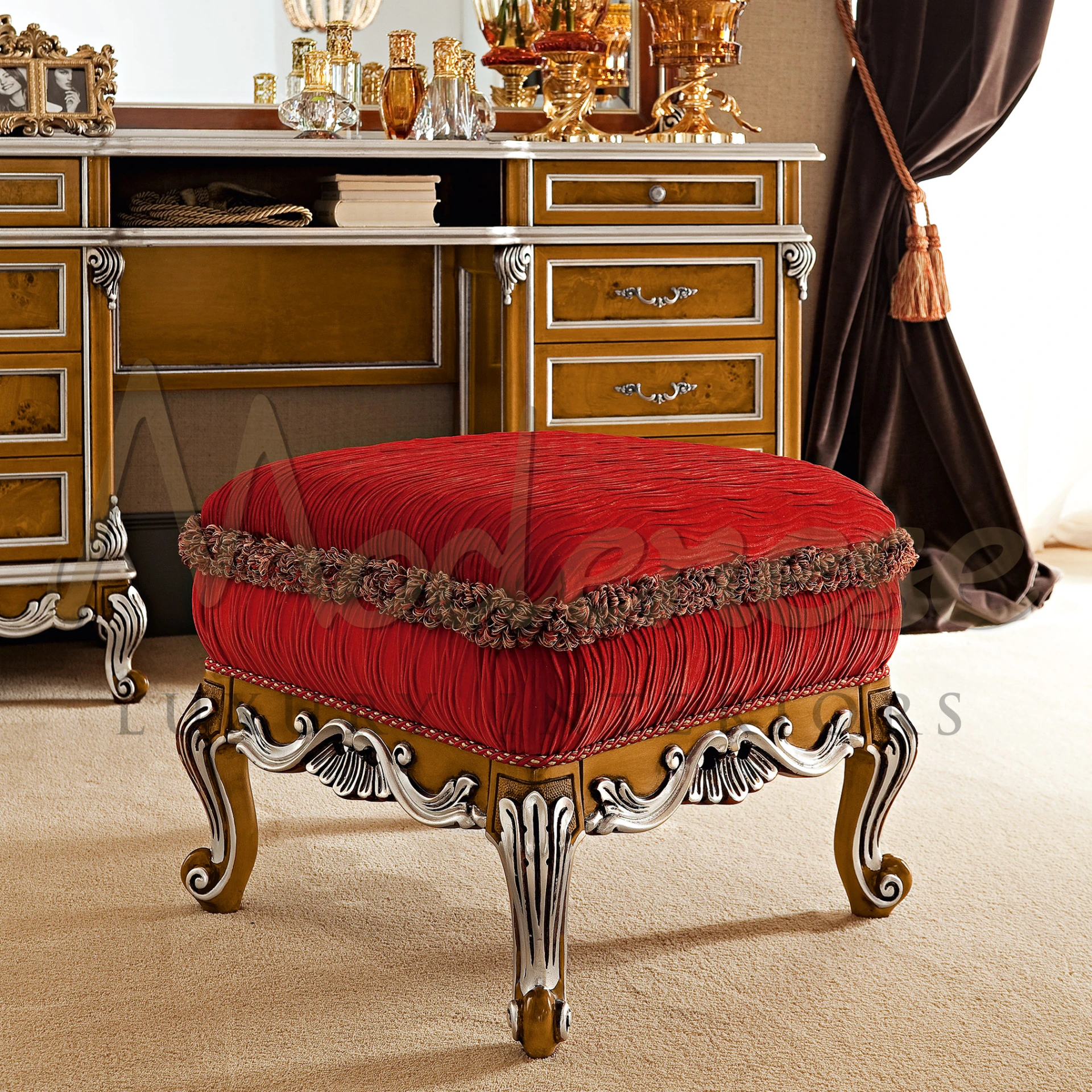 Opulent crimson velvet pouf with intricate gold carvings and a tasseled fringe                                                                        