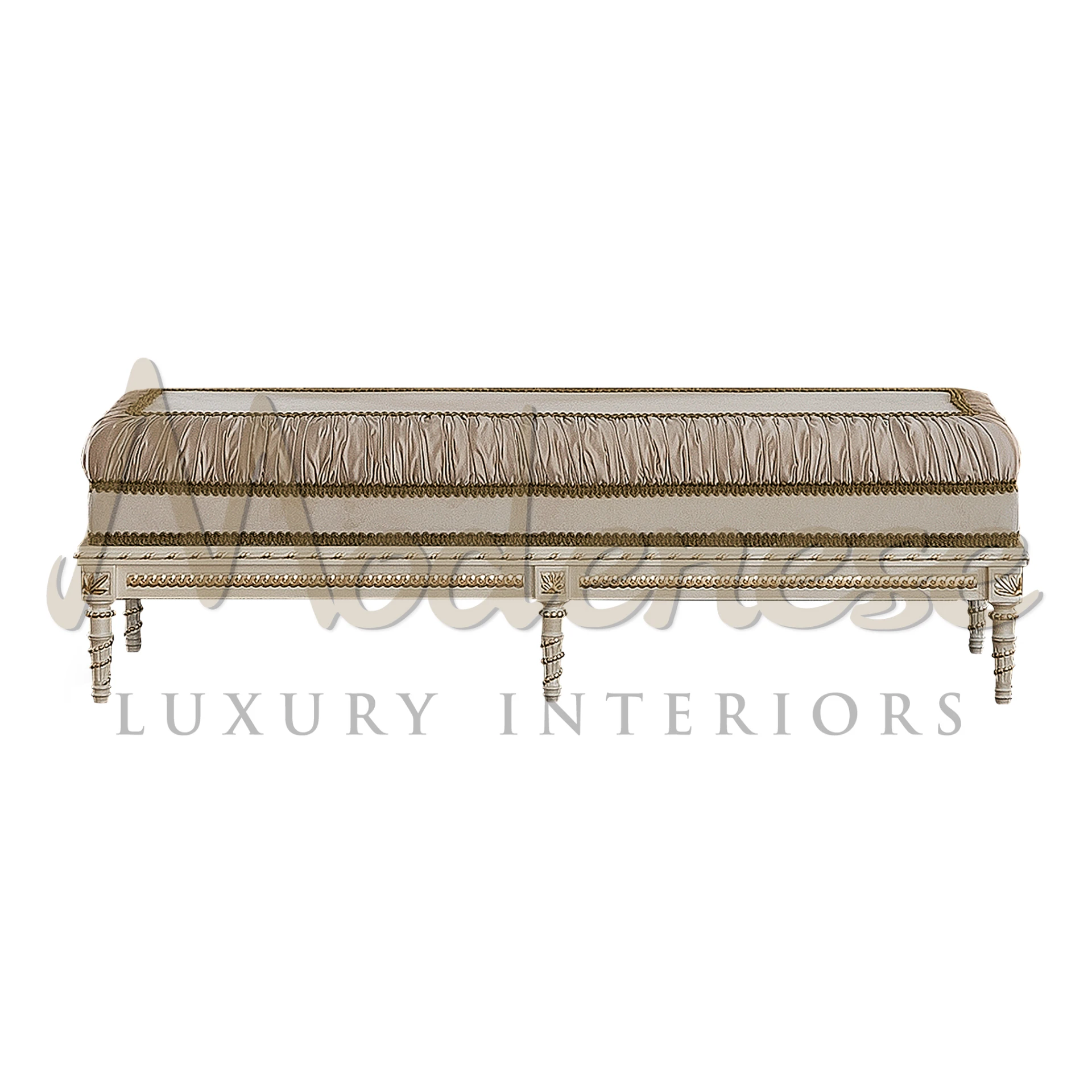 Beige upholstered bench with decorative fringe and ornate white legs.                                                                                                                     