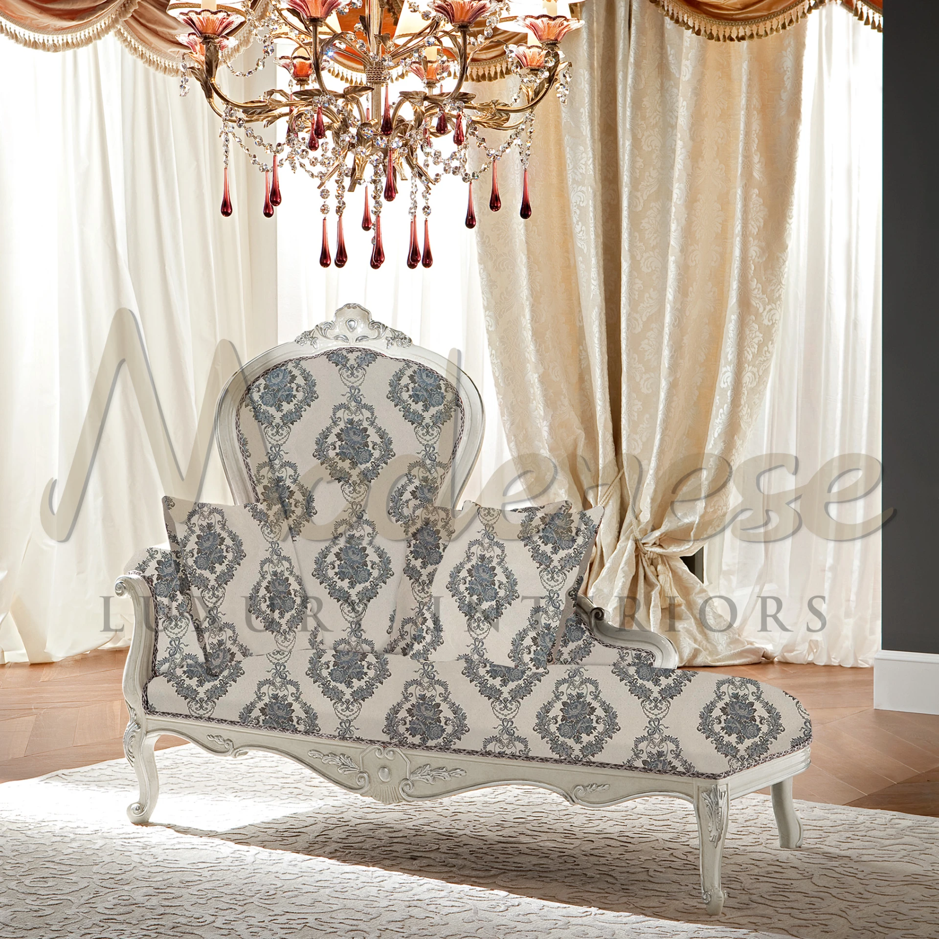 Classic cream-colored dormeuse with decorative blue and grey patterned upholstery and ornate wooden frame detailing, radiating vintage elegance.
