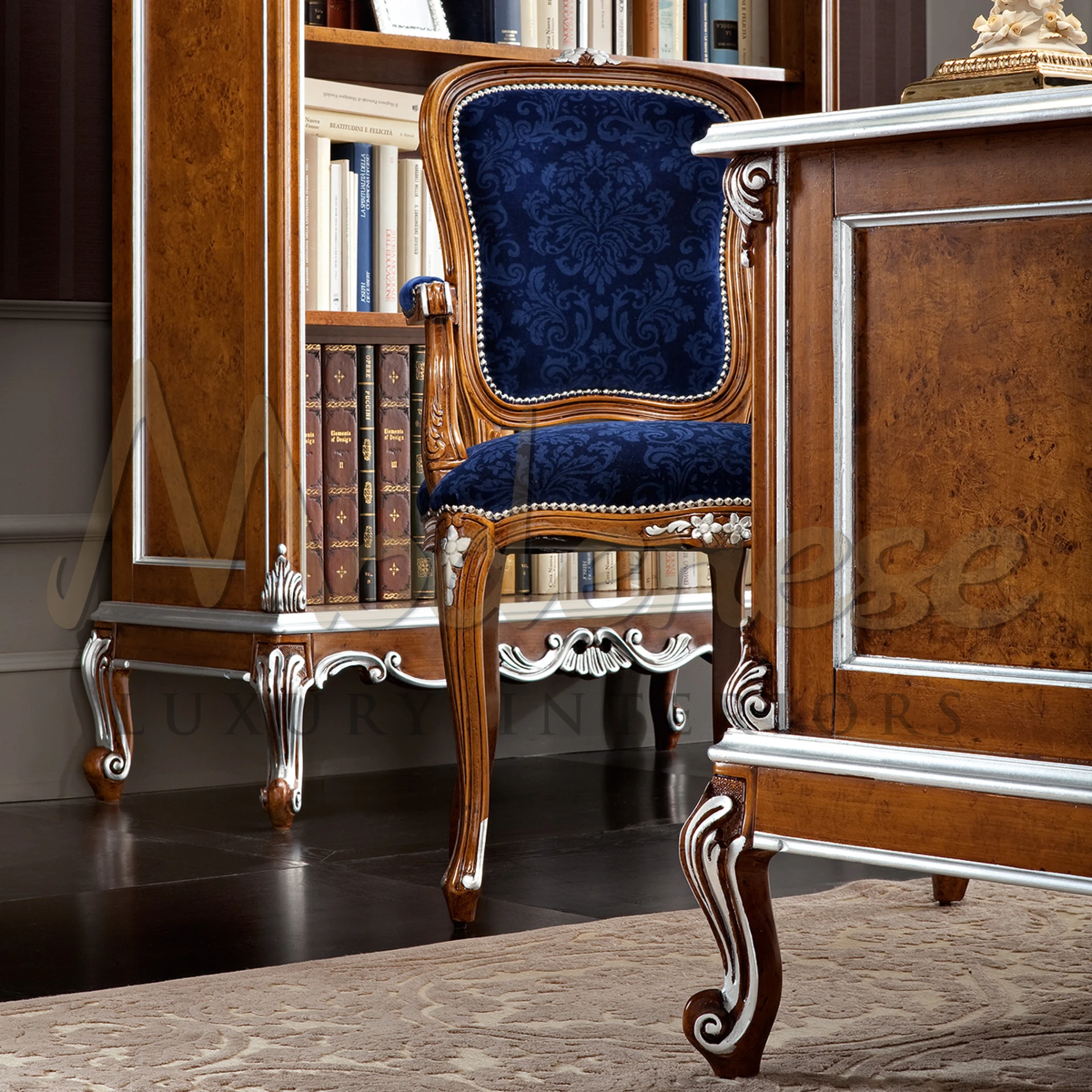 A wooden desk with a blue upholstered chair placed in front of a traditional bookcase - Modenese Luxury Furniture