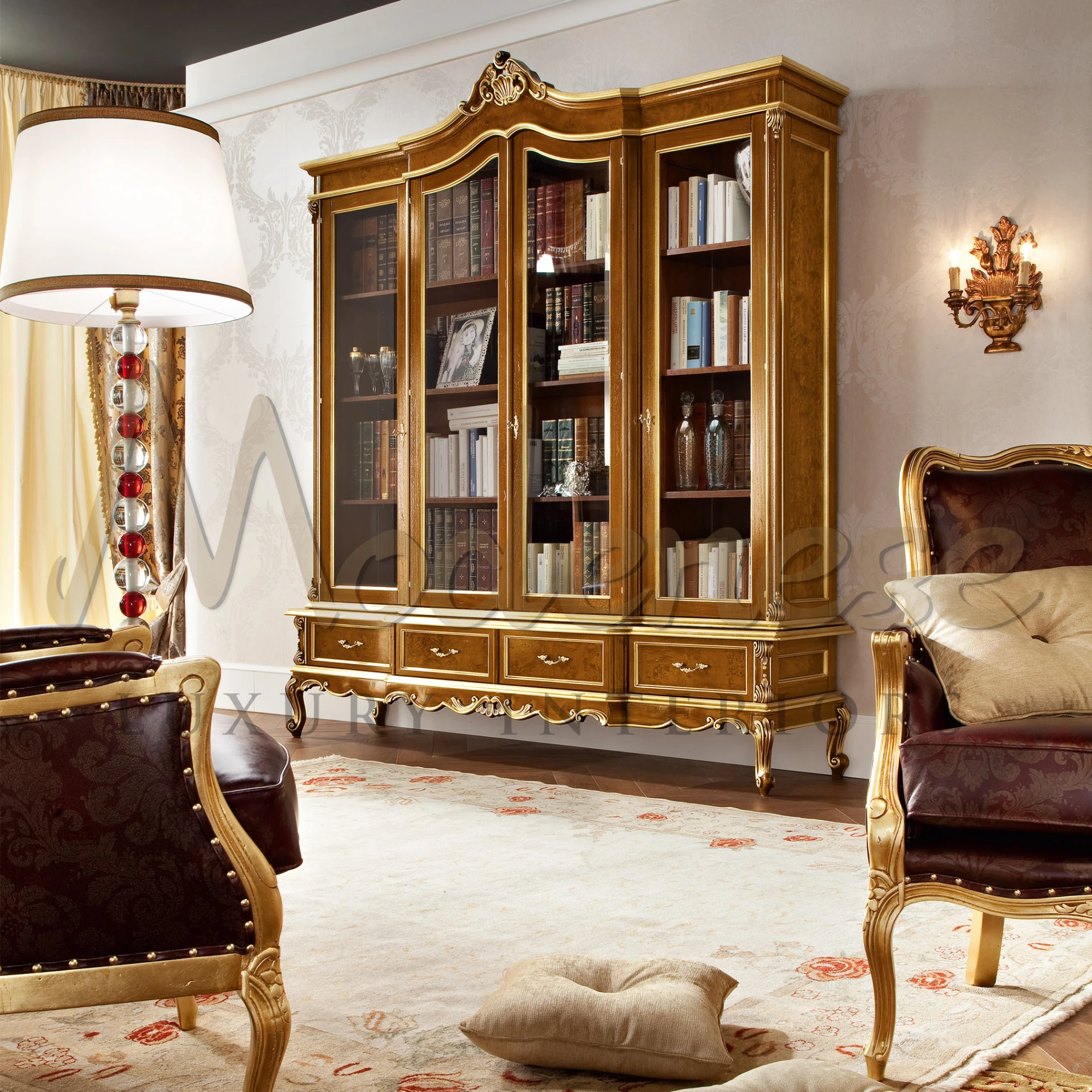 Living room with classical handmade bookcase with gold leaf detail along with chairs by Modenese Luxury Furniture