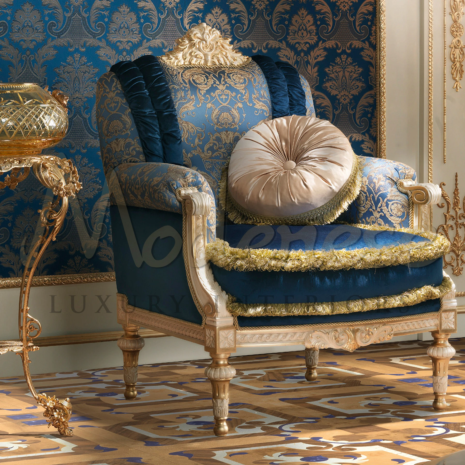 Luxurious blue and gold upholstered armchair with plush velvet seating and detailed damask backrest.