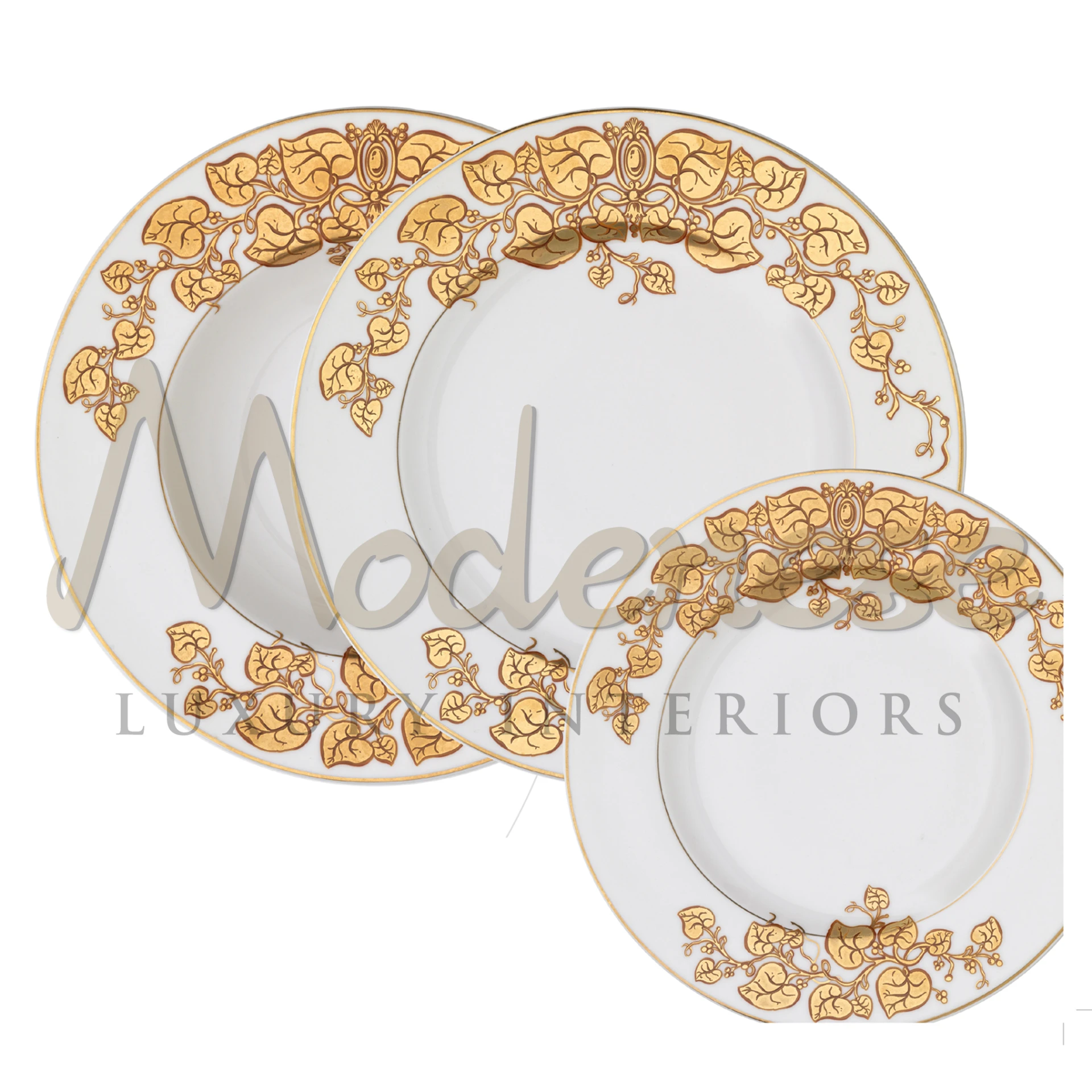 Three white porcelain plates of different sizes with golden floral designs on the corners.