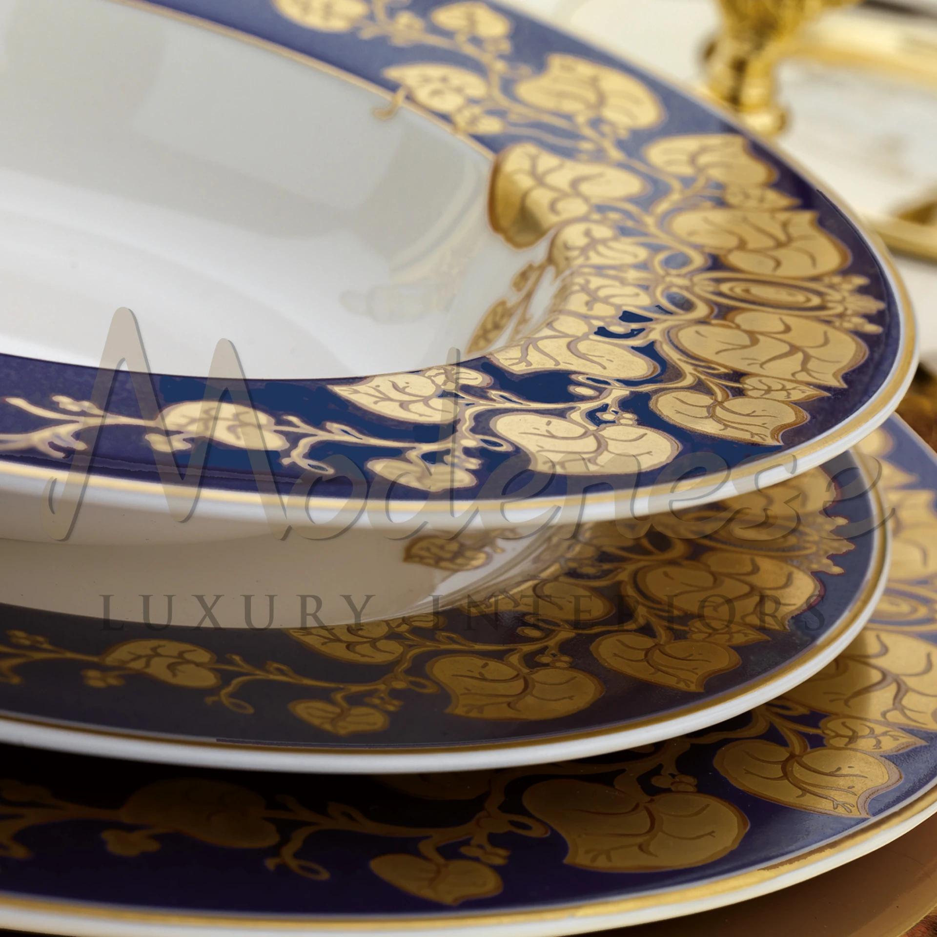 three elegant porcelain plates with a blue border and gold floral design.
