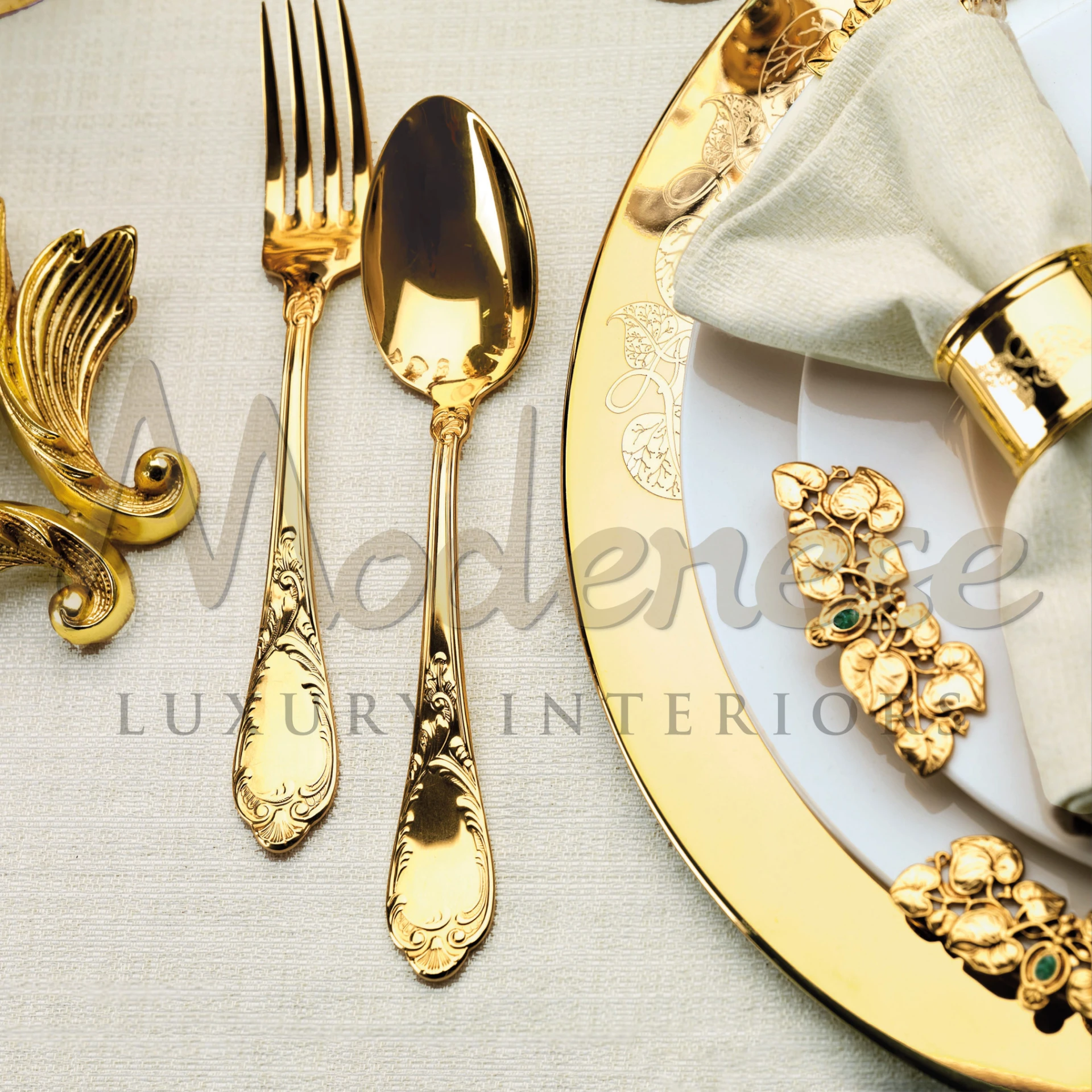 Luxurious gold cutlery and plate with intricate details and a napkin ring set