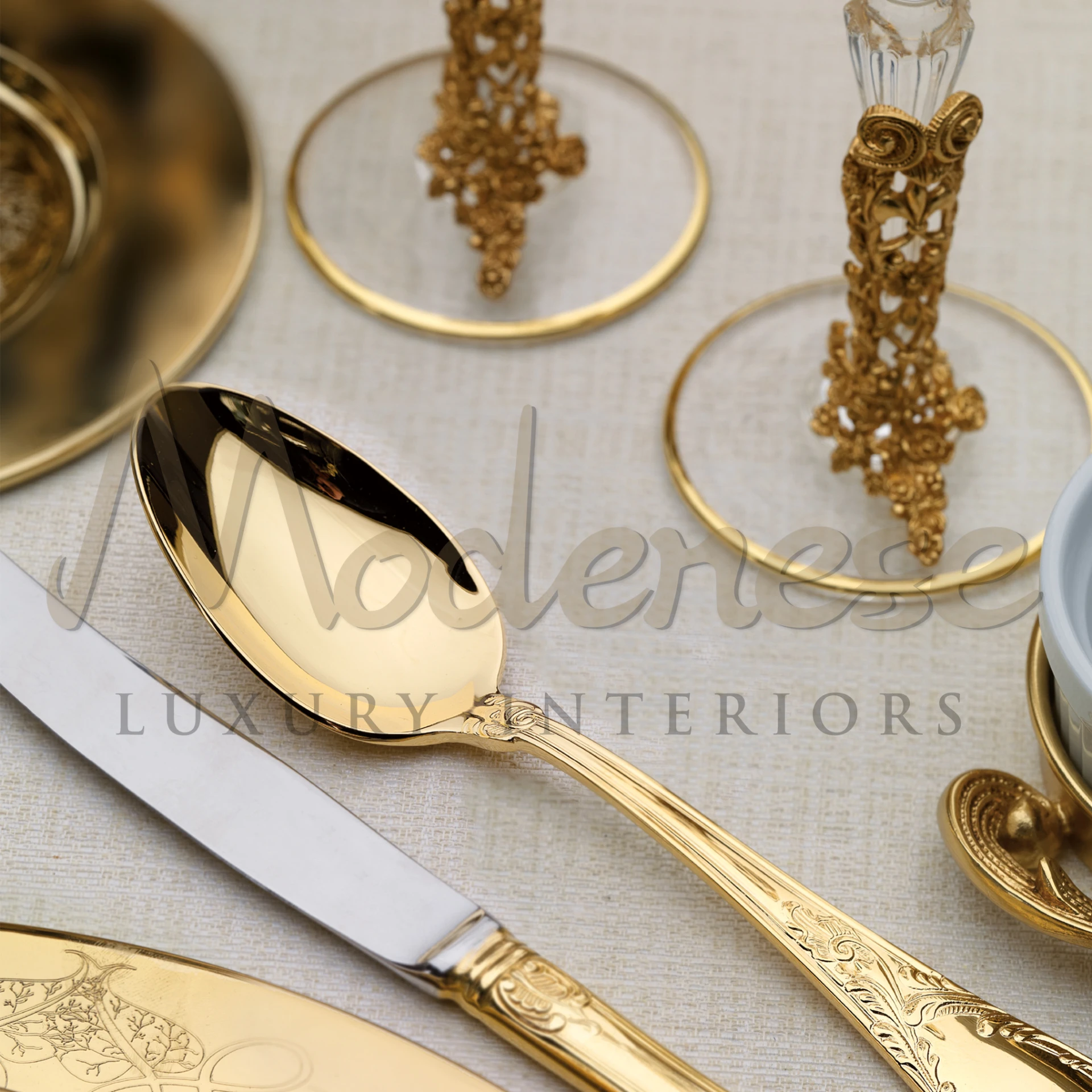 Golden spoon and knife with detailed engraving, part of a luxury dining set