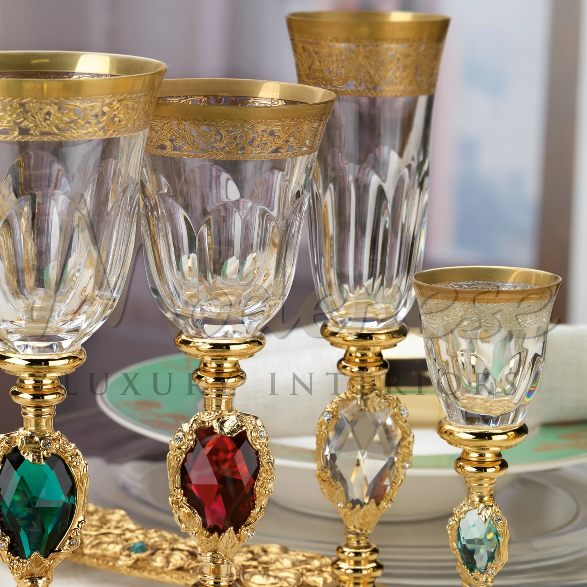 The exquisite crystal glasses with golden rims and gem-embedded stems, part of a lavish table setting.