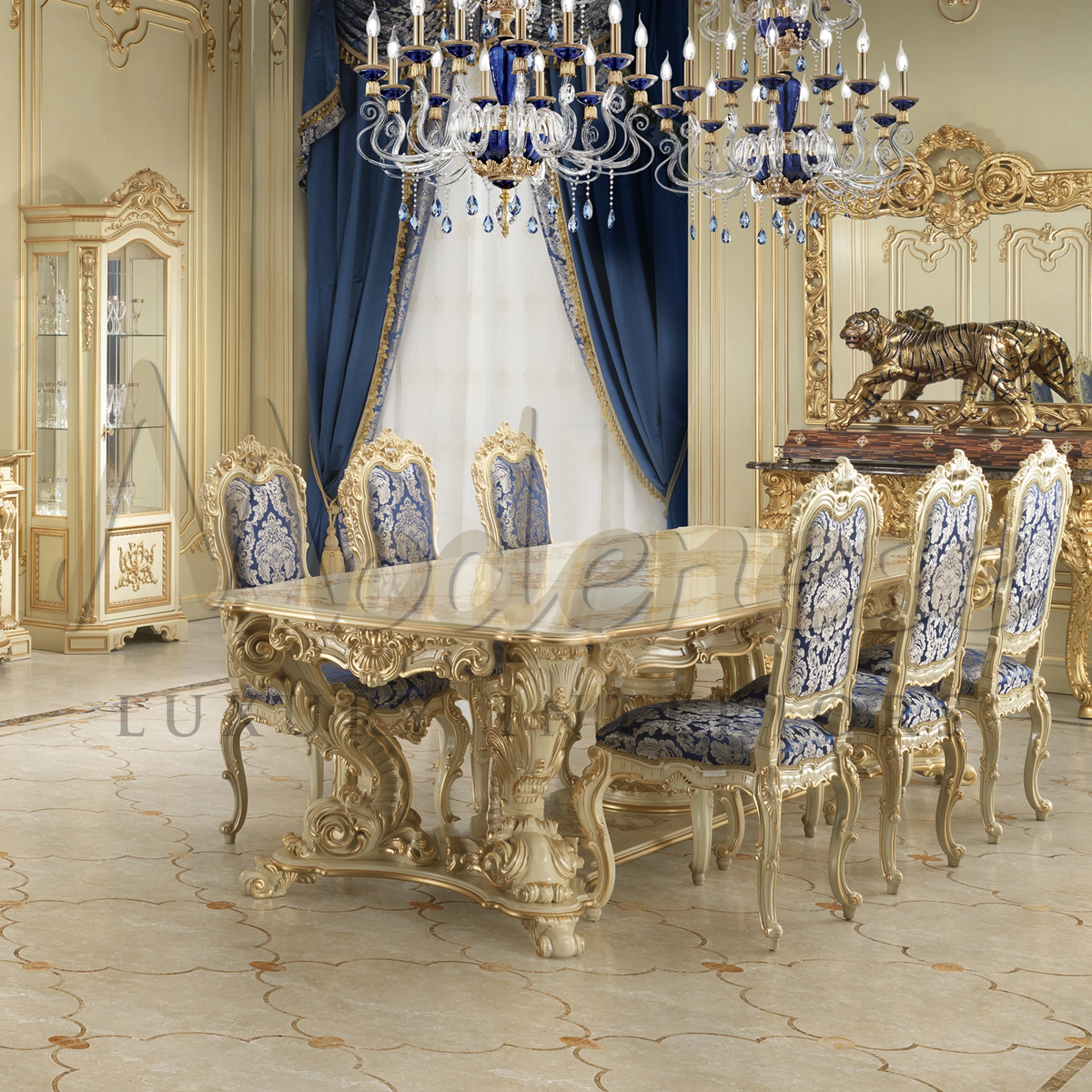 Fancy room with a sparkly light, white table with gold designs, and flowery chairs.