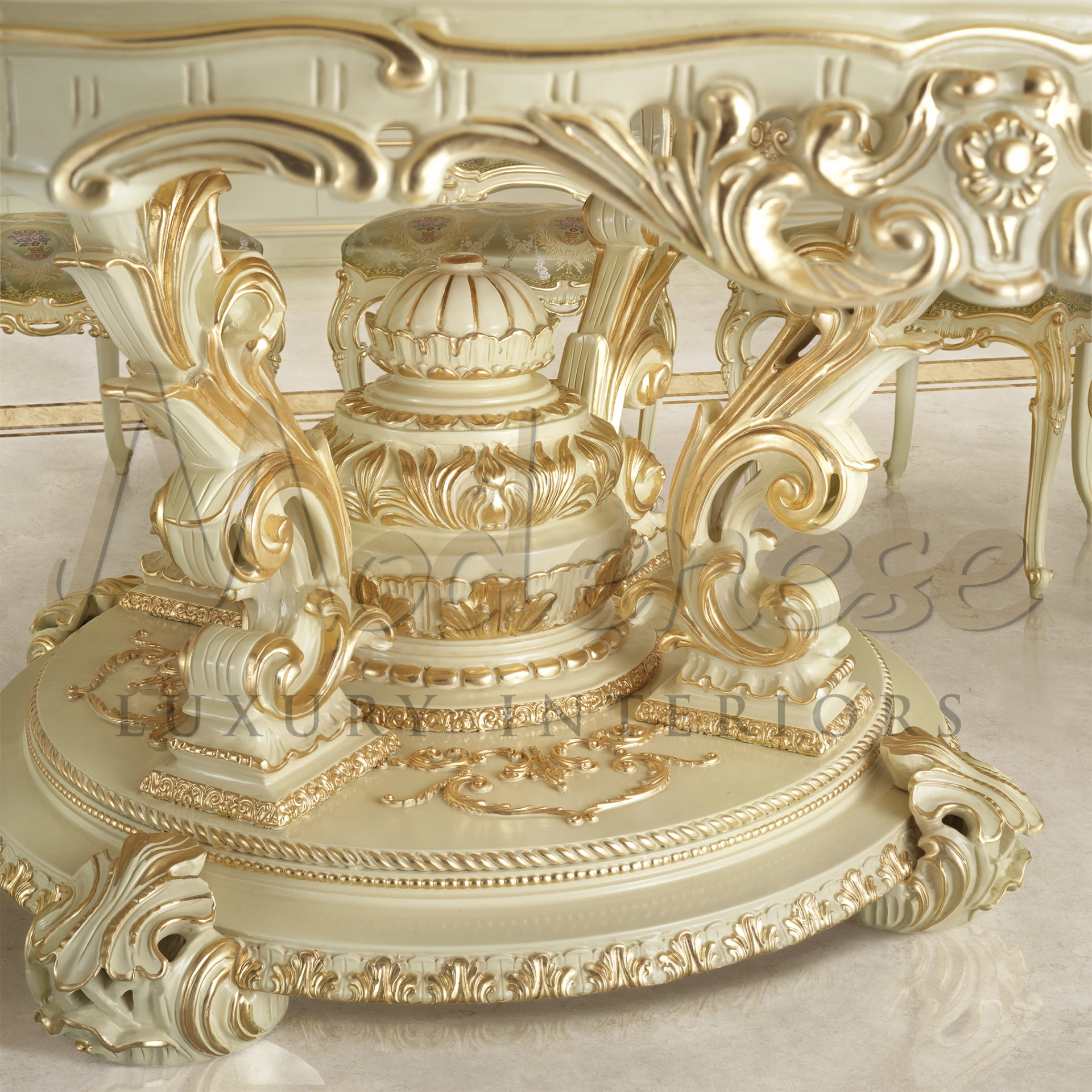 Close-up of a gold and white dining table base with an fancy gold carving