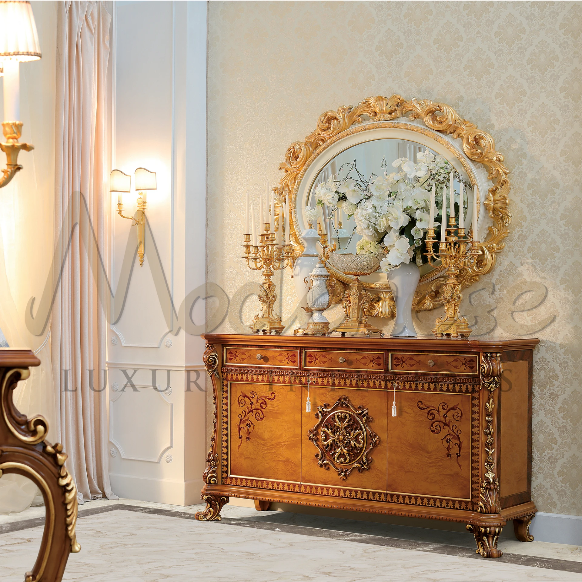 Fancy room with a gold mirror above a wooden Baroque Style Sideboard decorated with flowers.