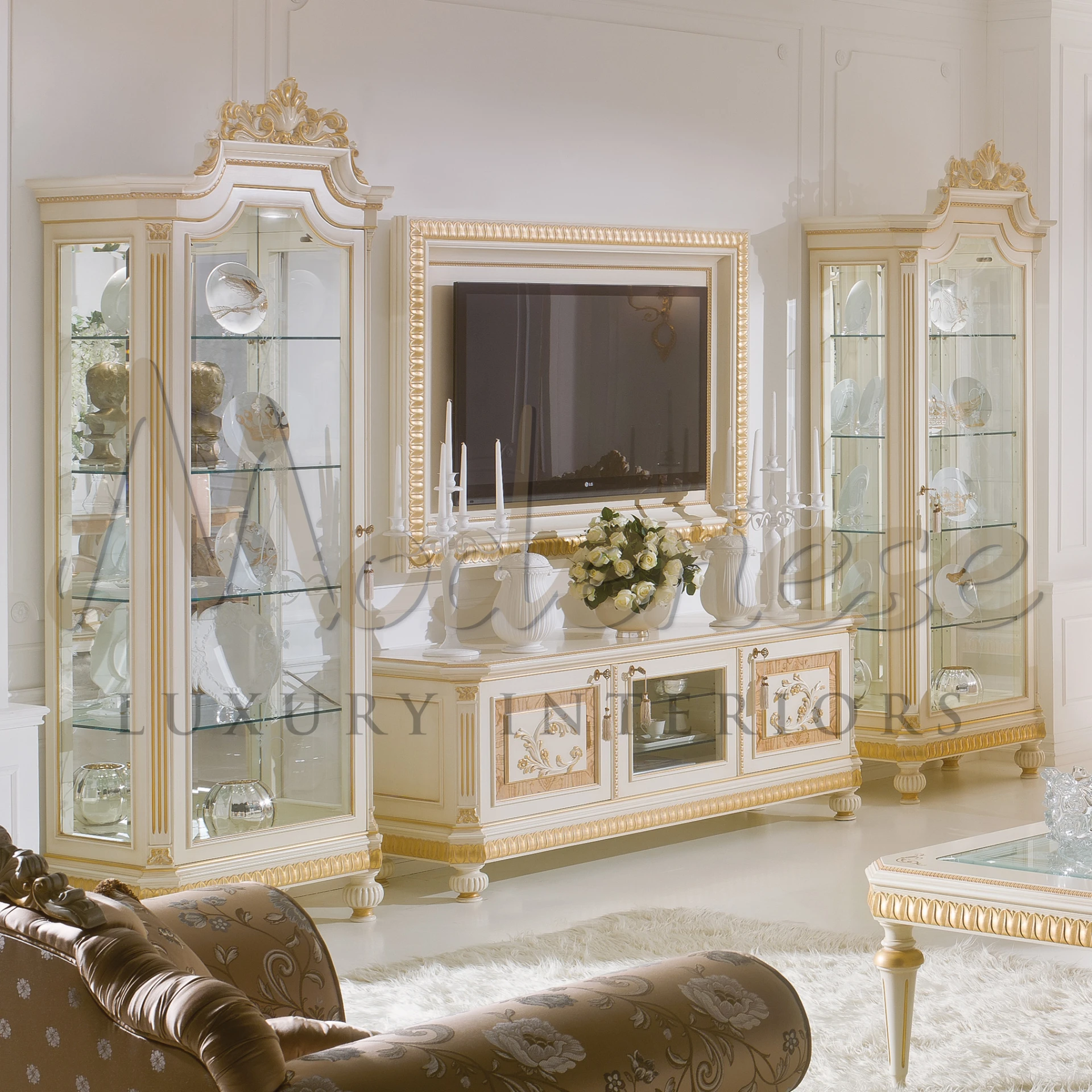 A beautiful decorated room with a big gold framed mirror and a wooden table, empire vitrine with golden patterns.
