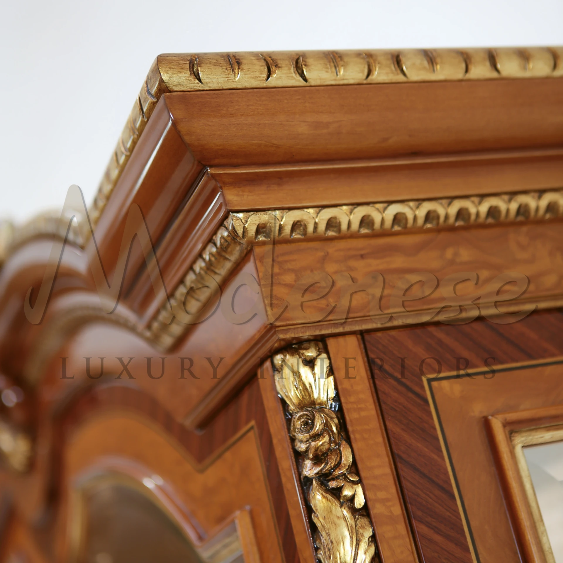 Close up view of the corners of the wooden cabinet with a complex golden design.