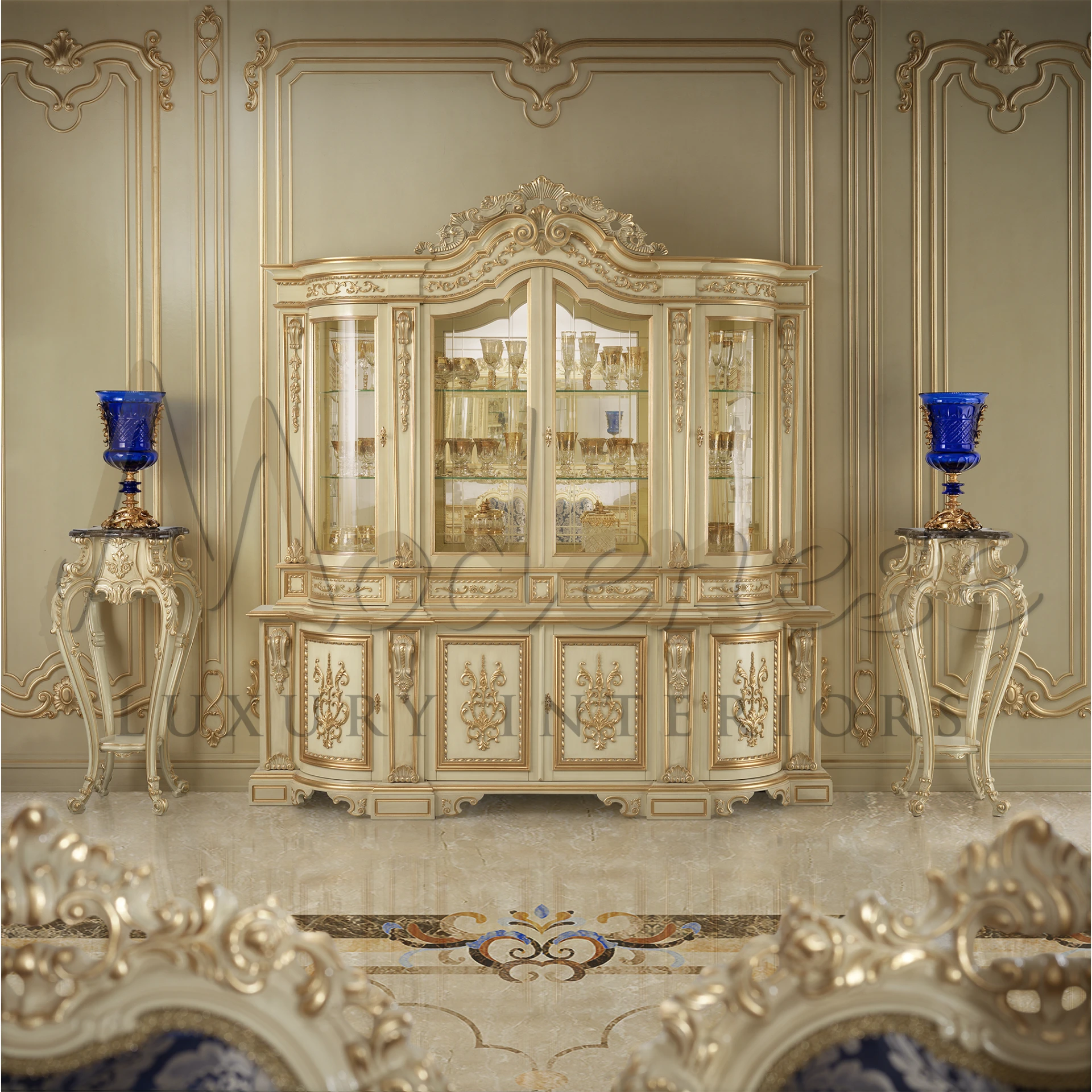 Fancy ivory cabinet with glass doors flanked by tall blue vases on stands