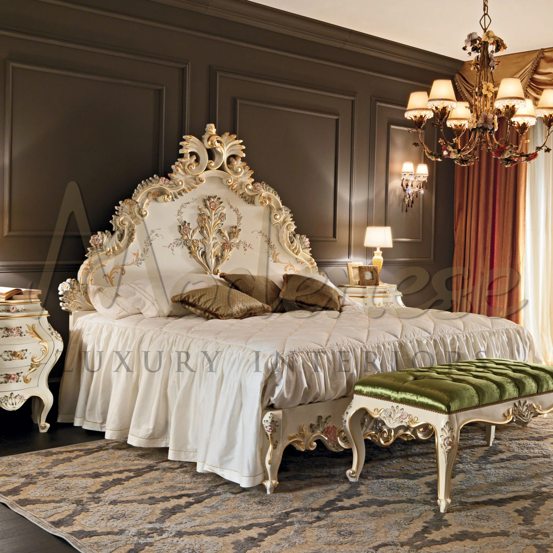 An elegant bedroom with a cream-colored, floral-carved headboard, a ruffled bedspread, a velvet bench, and a classical rug, exuding a warm, luxurious ambiance.